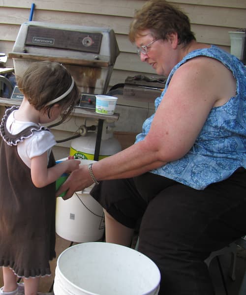 Merrilyn planting flowers with her granddaughter svanna